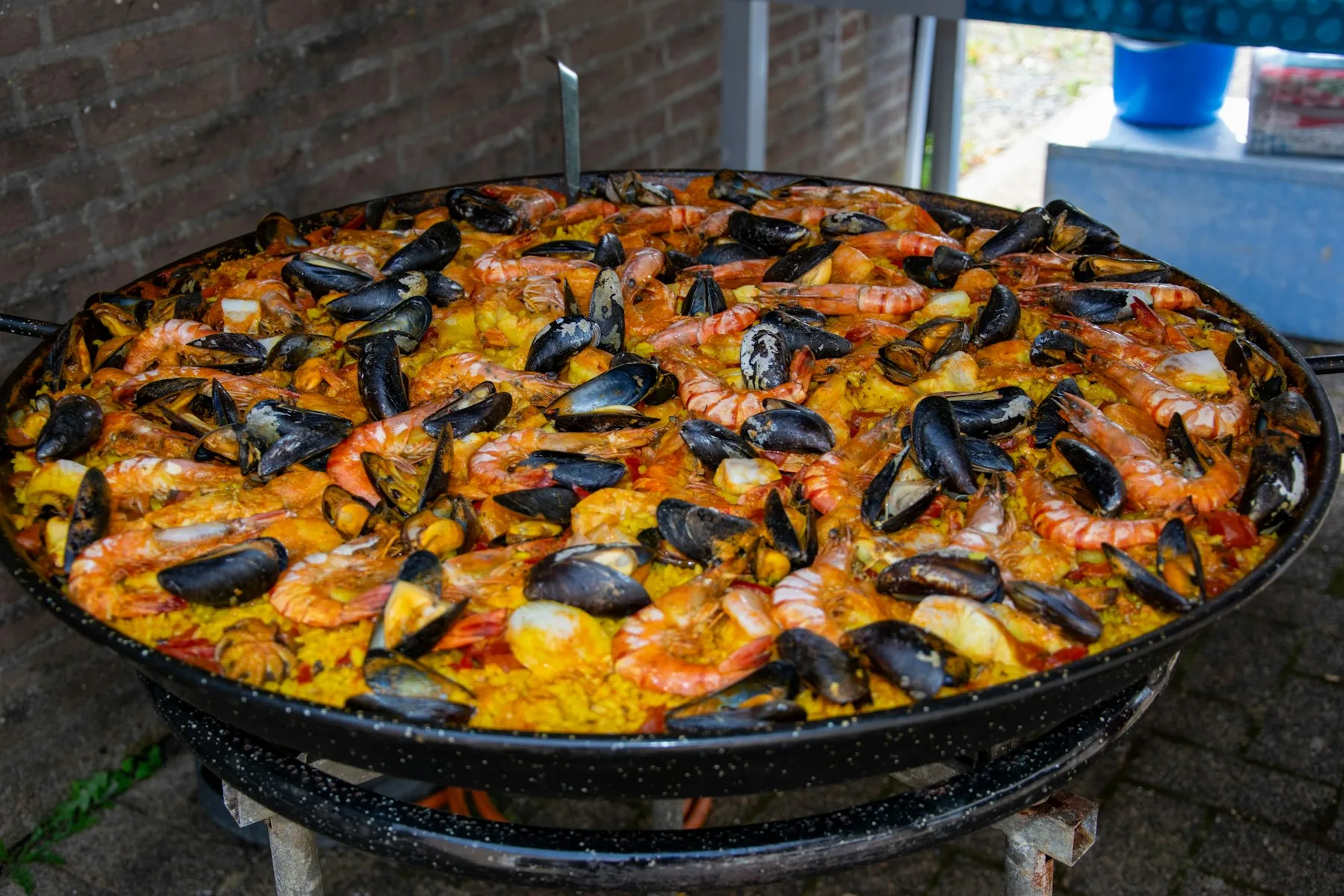 Grande paella aux fruits de mer en cuisson sur un brûleur